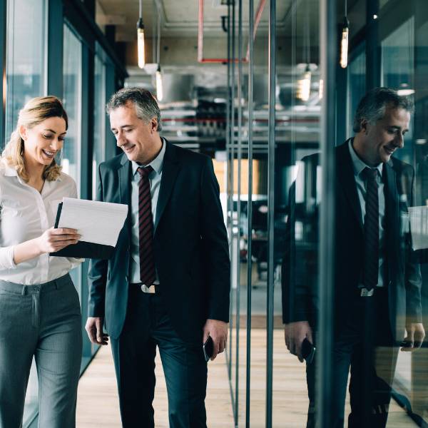 Il business unit manager di Canna parla con la sua selezionatrice in un corridoio dell'azienda