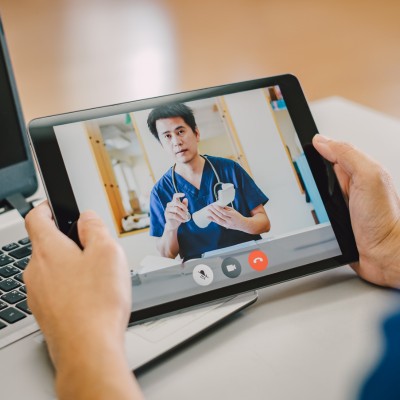 Una persona sta interagendo con un medico tramite un tablet