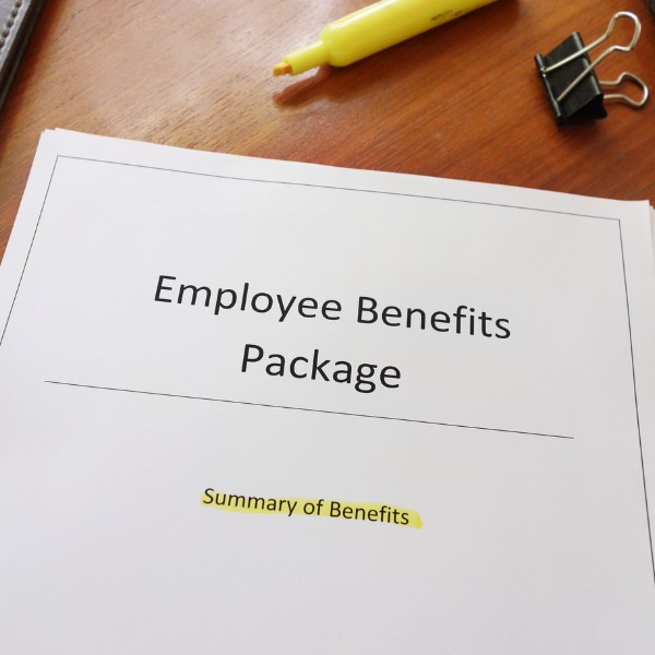 Un foglio su un tavolo con scritto "Employee Benefits Package. Summary of Benefits"