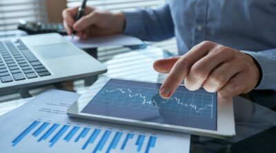 primo piano su un tablet e dei documenti nel settore finanaziario.