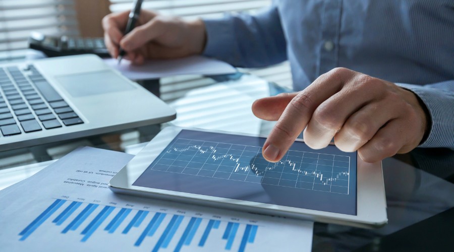 primo piano su un tablet e dei documenti nel settore finanaziario.