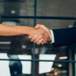 stretta di mano tra due collaboratori aziendali