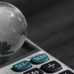 L'headhunter tax come partner per la crescita internazionale. L'immagine rappresenta un piccolo mondo su una calcolatrice