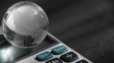 L'headhunter tax come partner per la crescita internazionale. L'immagine rappresenta un piccolo mondo su una calcolatrice