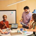 In questa immagine sono rappresentate delle persone che lavorano dialogando intorno ad un tavolo