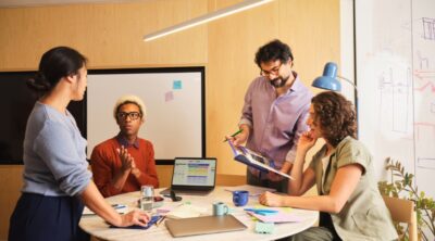In questa immagine sono rappresentate delle persone che lavorano dialogando intorno ad un tavolo